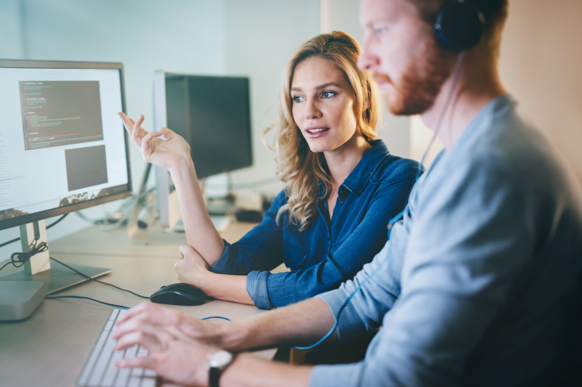 Two IT specialists working together at a workstation